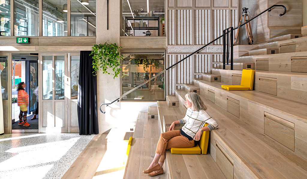 Woman sitting in Paddington Works auditorium space | Workspace in Paddington available to book on demand through Tally Market